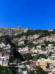 Colorful hillside village under a vibrant blue sky. Positano, Italy.