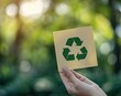 © Alexei - A person holds a paper featuring a recycling symbol