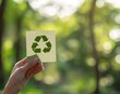 © Alexei - A person holds a paper featuring a recycling symbol