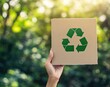 © Alexei - A person holds a paper featuring a recycling symbol