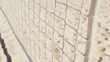 © Morto - A volleyball net with tensioned cables, outdoor setting on sand court, Minimalist style