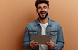 © aciddreamStudio - caucasian young male laughing holding a tablet on brown background
