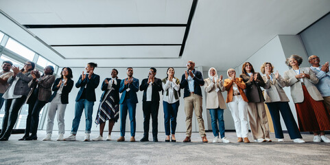 Wall Mural - diverse group of business people clapping at a seminar in a modern workshop
