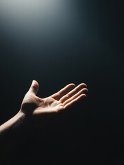 Wall Mural - hand reaching out in a dramatic lighting against a dark background