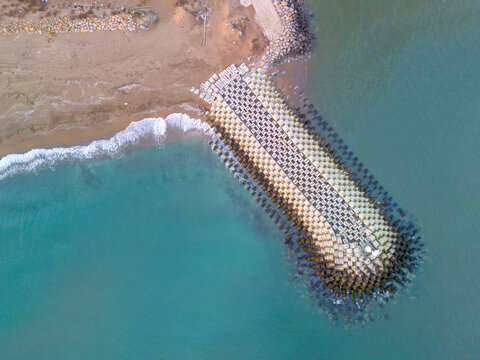 Sakarya Karasu Aerial View of Coastal Breakwater Structure Protecting Beach. High-angle, full shot of a breakwater extending into turquoise water, meeting the sandy beach. ADAPAZARI TURKEY TURKIYE 