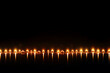 © efendiahd - Candles Reflecting on Dark Water: A Serene Nighttime Still Life Photography