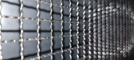 Close up view of stainless steel net with beautiful bokeh