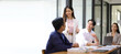 © Wasan - Asian businesswoman leader discussing business planning idea presentation with colleagues in conference room at office.