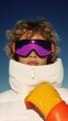 © anatolii - Stylish young person wearing colorful ski gear and goggles against a clear blue sky during a winter sports day