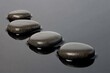 © Mandeep - smooth black stones in tranquil water for relaxation and wellness