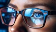 © intricateflow - A close up view of the eyes and spectacles with blue light reflections from the computer screen; up and close to a person's eyes wearing glasses with blue light ray from the monitors; technology