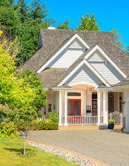 Wall Mural - Entrance of grey painted luxury house in summer with stair steps and nice landscape in Vancouver, Canada, North America. Day time on June 2024.