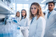 © romanets_v - Caucasian female scientist in a laboratory with colleagues