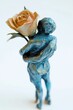© jambulart - Blue figurine embraces a pastel rose.