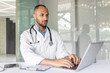 © Liubomir - A focused doctor in a white lab coat uses a laptop for clinical research, patient documentation, or healthcare administration, showcasing professionalism in the medical workplace.