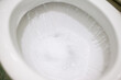 © Vitalii - Flushing toilet after using it. Much foam in lavatory pan, close up of flushing toilet