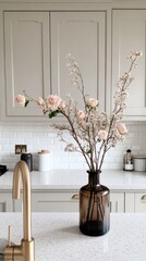 Wall Mural - A stylish kitchen showcases a gold faucet next to a black sink. A vase of peach and cream roses adds warmth to the modern design, enhancing the overall atmosphere