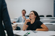 © qunica.com - Students are actively engaged in a classroom setting, working on assignments with the professor providing guidance. The focus is on learning and intellectual curiosity.
