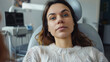 © Kosin - Sick young woman sitting in dental chair, looking concerned and tired. atmosphere is calm, with dental equipment visible in background