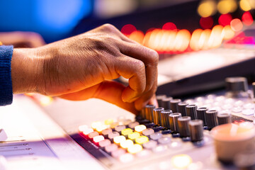 Poster - African american sound engineer operates audio console in control room, pushing faders and twisting knobs to adjust settings on tracks. Music producer composing new music in studio. Close up.