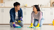 © Prostock-studio - Young asian couple cleaning floor together at kitchen and talking. Positive millennial man and woman house-keeping together at weekend, rubbing floor with dust cloth and cleaning sprays