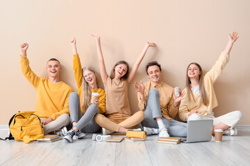 Canvas Print - Group of students sitting on floor near pale yellow