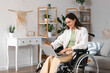 © Pixel-Shot - Young woman in wheelchair using laptop at home