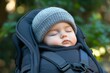 © Rosshahizal Amri - Sweet sleeping baby in a cozy carrier, wrapped warmly in soft fabric, enjoying a peaceful nap outdoors surrounded by nature's greenery and tranquility