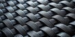 © Pluto - Close-up view of a complex, interwoven dark gray textile pattern showing intricate details of the woven structure