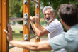 © auremar - smiling athletic men exercising together on horizontal bar