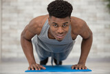 portrait of a fitness man doing push ups in gym