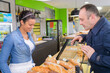 © auremar - male customer being served at the bakery counter