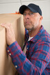 © auremar - mature delivery man struggles with a parcel