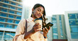 © ChasingMagic/peopleimages.com - Happy, business woman and browsing with phone in city for social media, communication or reading news. Low angle, female person or employee with drink or mobile smartphone for online chatting or app