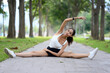 © Prathankarnpap - Young fit woman doing stretching exercises on path in serene park