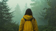 © A je - A woman in a yellow raincoat walking in a foggy forest