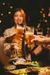 © Witoon - A group of fun friends gather outdoors, raising their glasses in celebration. They smile and laugh, enjoy beers and have lively conversations, showing friendship, fun.