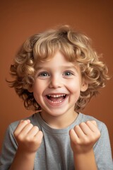 Sticker - A young boy with blonde hair is smiling and holding his hands up in the air. He is wearing a gray shirt and he is happy