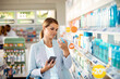 © Davor - Young woman browsing shelfs of pharmacy drug store