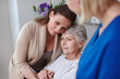 © peopleimages.com - Daughter, senior person and nurse in clinic for visit, diagnosis or comfort as cancer patient. Elderly woman, family and healthcare services for empathy, support or consultation in doctor appointment