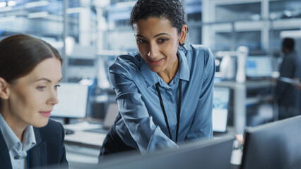 Poster - Caucasian Female Engineer And Hispanic Product Manager Using Desktop Computer And Talking At Automated Factory With Robotic Hands. Indian Facility Worker Using Soldering Jet Printer On Background.