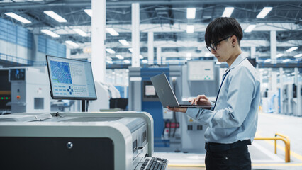 Poster - Asian Male Engineer Using Laptop To Control Soldering Jet Printer On Modern Electronics Factory. Man Working On Production Of Innovative Printed Circuit Boards For Artificial Intelligence Systems.