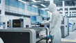 © Gorodenkoff - Printed Circuit Board Production In Electronics Factory Cleanroom: Scientist In Sterile Suit Using Soldering Jet Printer To Make Motherboards For Powerful CPU. Computer Hardware Manufacturing Facility