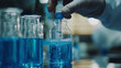 © aiken - scientist in blur gloves with glass flask and test tube in research science lab banner background