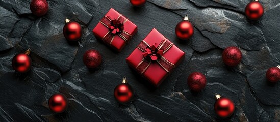 Aufkleber - Red Christmas gift boxes and shiny ornaments on a dark stone surface arranged from a top view perspective during the holiday season.