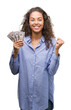 © Krakenimages.com - Young hispanic woman holding dollars screaming proud and celebrating victory and success very excited, cheering emotion