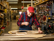 © Hendra - elderly man working with table on hardware store