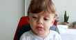 © Marco - Cute baby toddler infant blond boy close-up face portrait on highchair