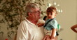 © Marco - Grand-father holding baby grandson in arms