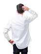 © Krakenimages.com - Young handsome business man wearing glasses over isolated background Backwards thinking about doubt with hand on head